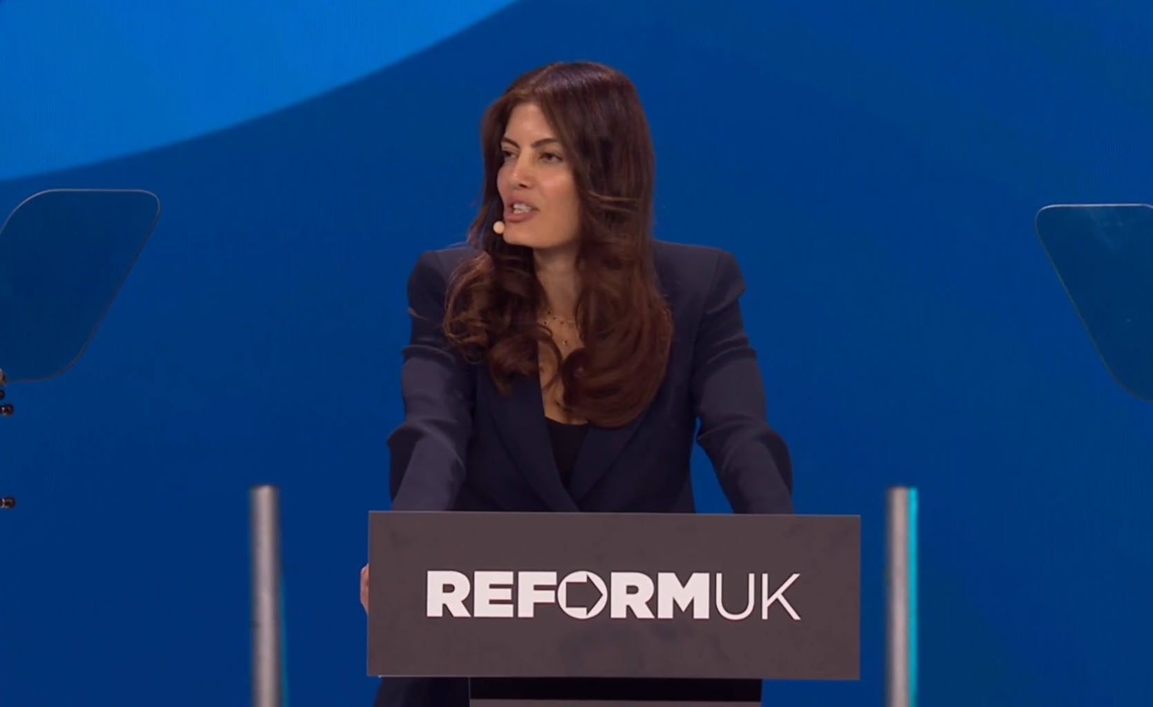 Laila Cunningham speaks at Reform UK Conference 2026 in Birmingham, addressing delegates from the Reform UK podium in a navy blazer.
