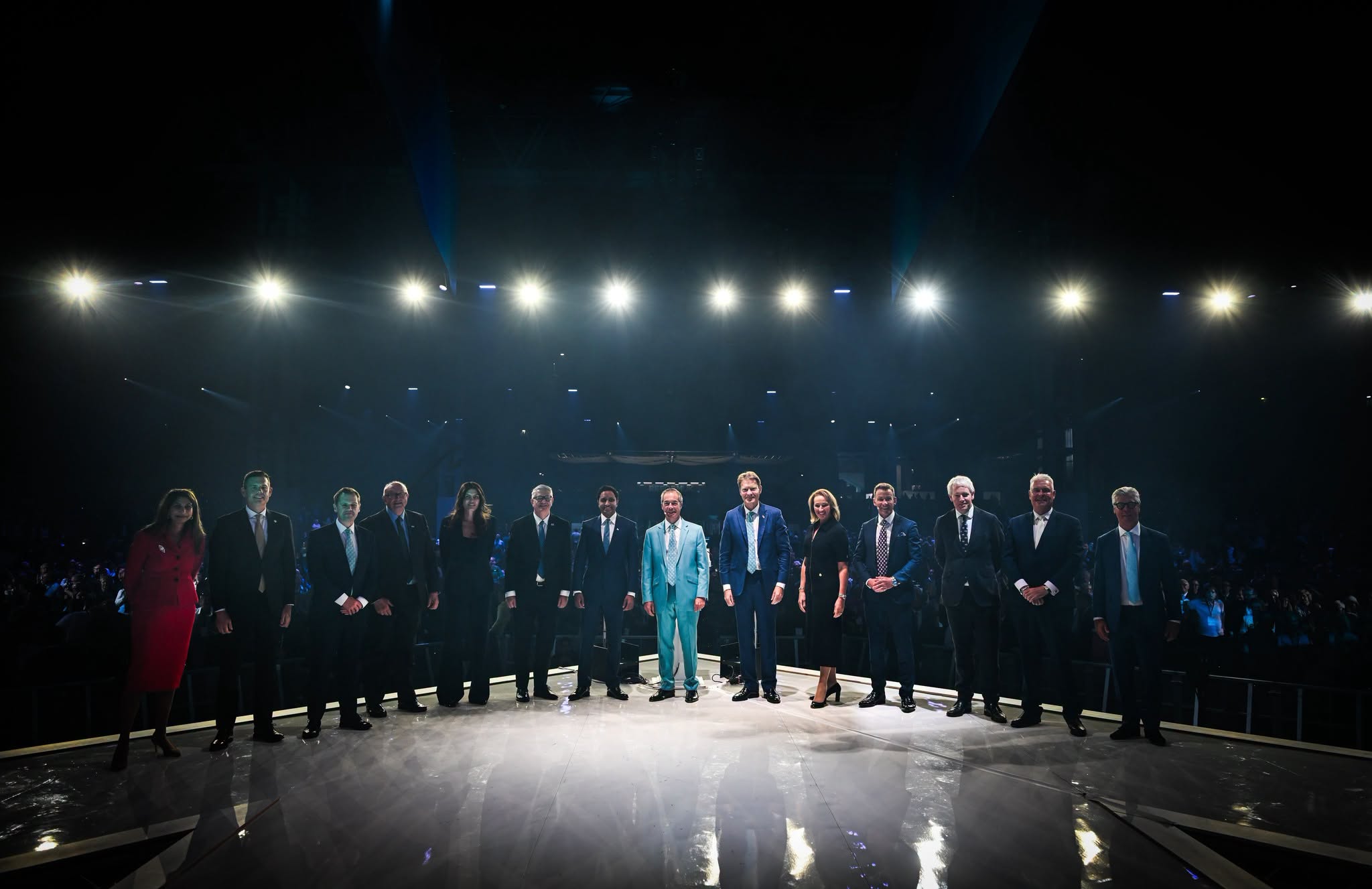 Reform UK Conference 2026 leadership team lined up on the Birmingham stage at the finale, with Nigel Farage in a turquoise suit at centre and Richard Tice beside him.