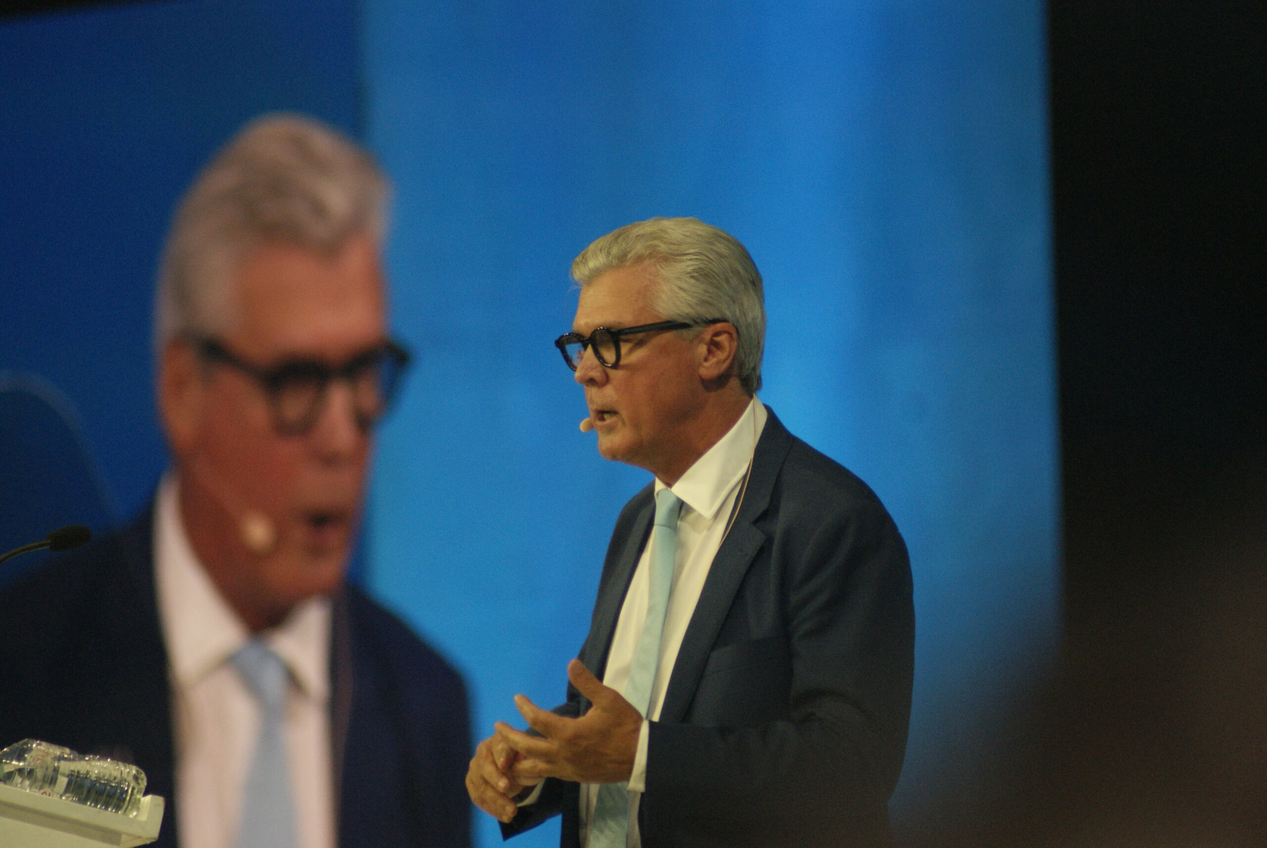 Malcolm Offord in profile at Reform UK Conference 2026, gesturing as he delivers his speech against a blue stage backdrop.