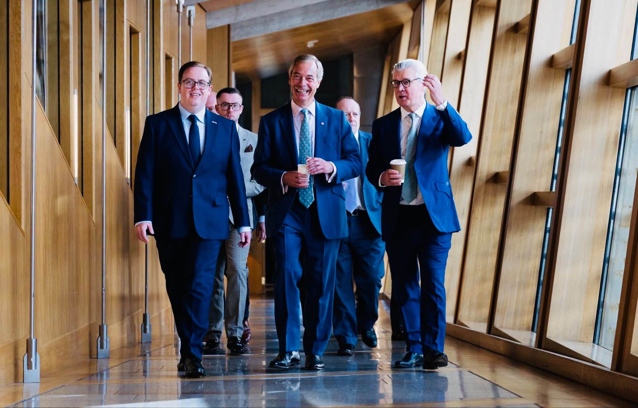 Nigel Farage walks a Holyrood corridor with Malcolm Offord and Reform MSPs, 28 September 2026.