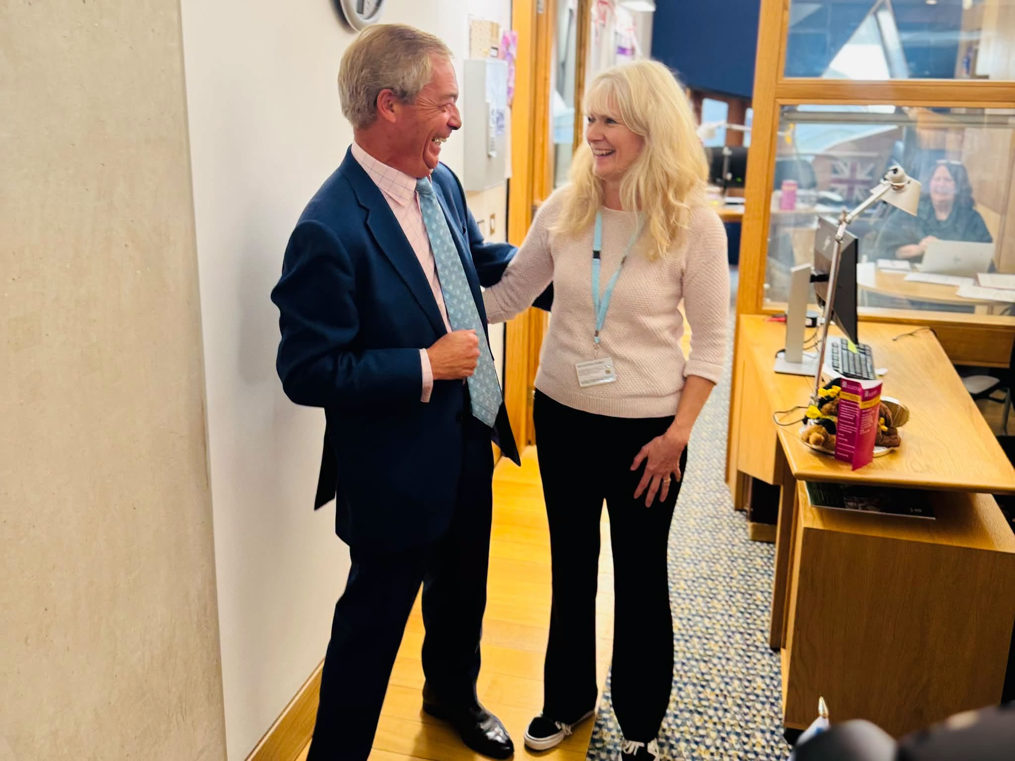 Nigel Farage shares a joke with a member of Reform's Holyrood staff.