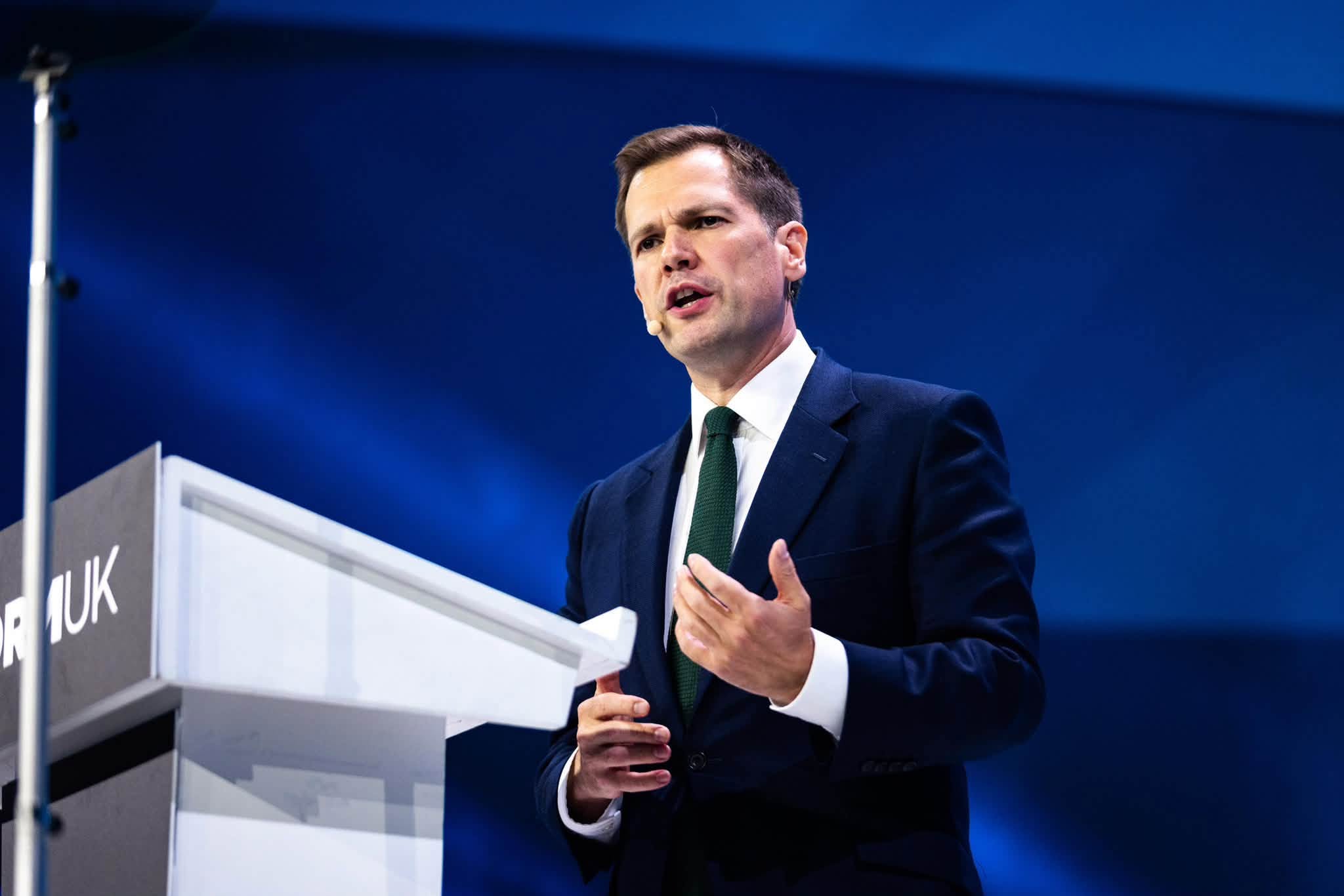 Robert Jenrick speaks at the Reform UK Conference 2026 podium in Birmingham, gesturing as he sets out the personal allowance pledge.