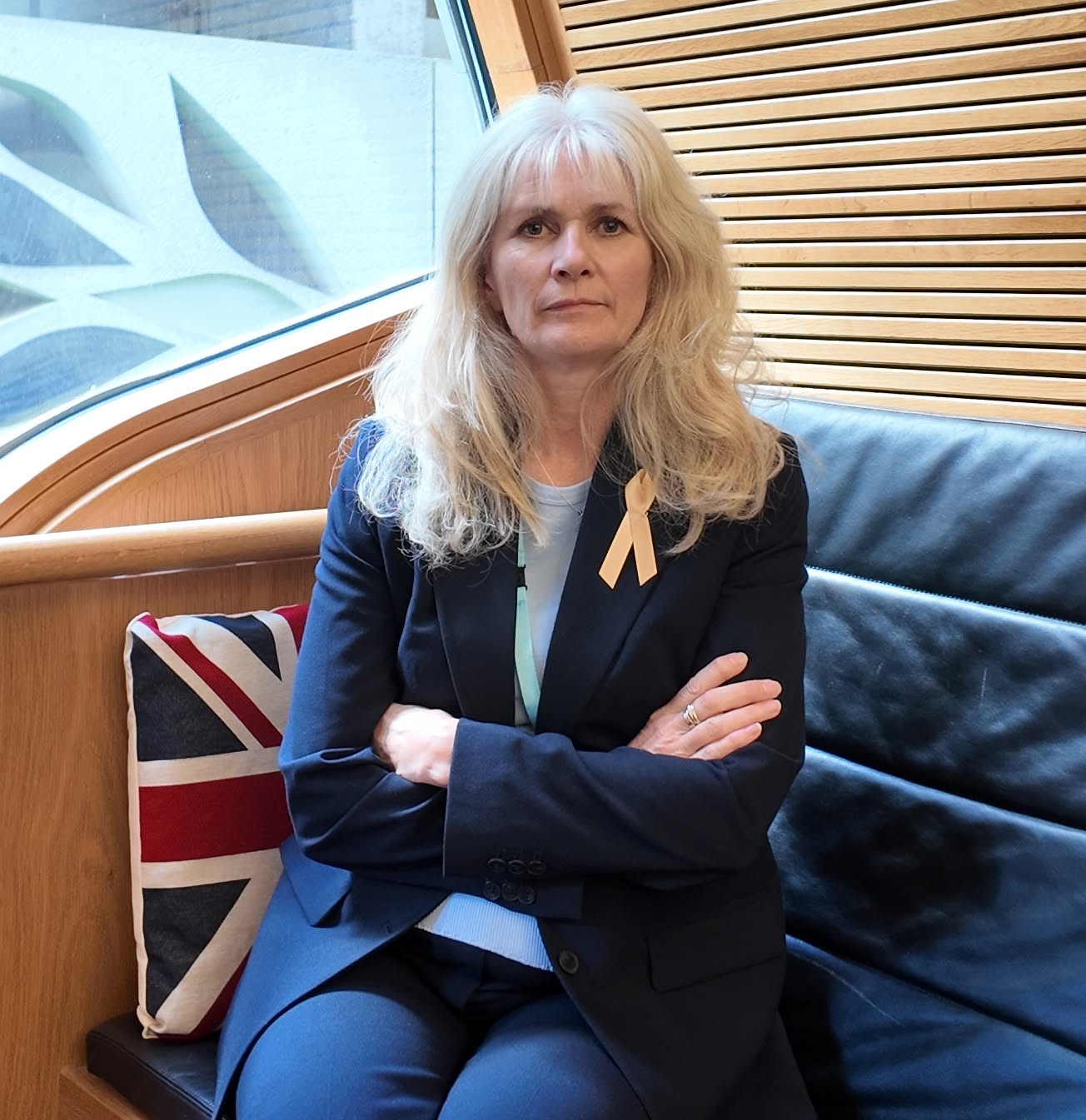 Amanda Lindsay MSP, seated with her arms folded.